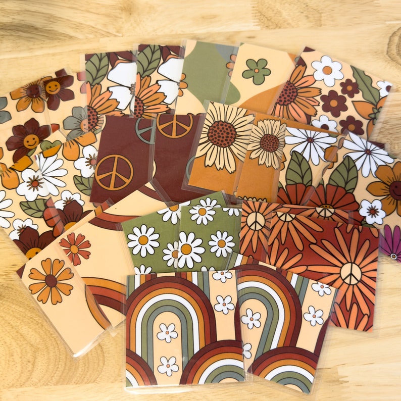 May include: A set of 16 vintage-style patterned cards featuring flowers, peace signs, and rainbows in shades of brown, orange, green, and white.