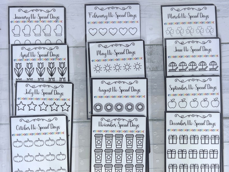 May include: A set of 12 printable cards for a no-spend challenge. Each card features a different month of the year and a corresponding icon. The icons include mittens, hearts, shamrocks, tulips, suns, beach umbrellas, stars, sunflowers, apples, pumpkins, coffee cups, and gift boxes.