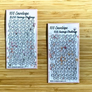 May include: Two printable 100 envelope savings challenge cards. The cards are pink with a floral design and have black circles with numbers inside. The top card says "100 Envelope $5,050 Savings Challenge" and the bottom card says "100 Envelope 10K Savings Challenge".