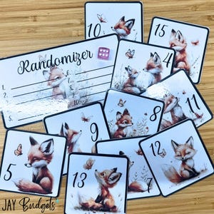 May include: A set of 13 cards featuring a fox illustration with a butterfly and a number on each card. The cards are white with black borders and are part of a game called "Randomizer".