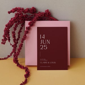 May include: Save the date card with a burgundy background and pink border. The card features the date "14 JUN 25" and the text "Save the date for the wedding of CLAIRE & LOUIS. Formal invitations to follow."