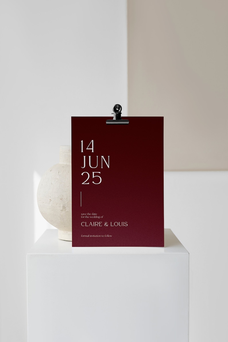 May include: A burgundy save the date card with white text. The card reads "14 JUN 25" and "save the date for the wedding of CLAIRE & LOUIS formal invitation to follow".
