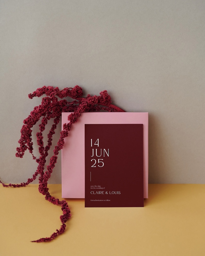 May include: Save the date card with a burgundy background and pink border. The card features the date "14 JUN 25" and the text "Save the date for the wedding of CLAIRE & LOUIS. Formal invitations to follow."