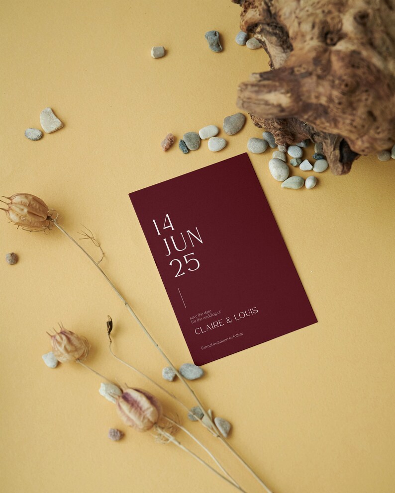 May include: A burgundy save the date card with white text. The card reads "14 JUN 25" and "Save the date for the wedding of CLAIRE & LOUIS. Formal invitation to follow."