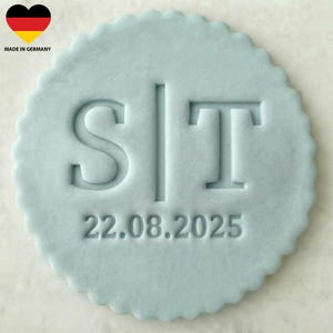 Könnte beinhalten: Ein hellblauer, kreisförmiger Stempel mit einem gezackten Rand. Der Stempel zeigt die Buchstaben "ST", getrennt durch eine vertikale Linie, und das Datum "22.08.2025" steht darunter. Die deutsche Flagge und "MADE IN GERMANY" befinden sich in der oberen linken Ecke.