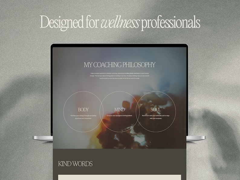May include: A laptop displaying a webpage with the text "Designed for wellness professionals." The webpage features the title "MY COACHING PHILOSOPHY" and sections labeled "BODY," "MIND," and "SOUL." The background is a soft, blurred image with neutral tones.