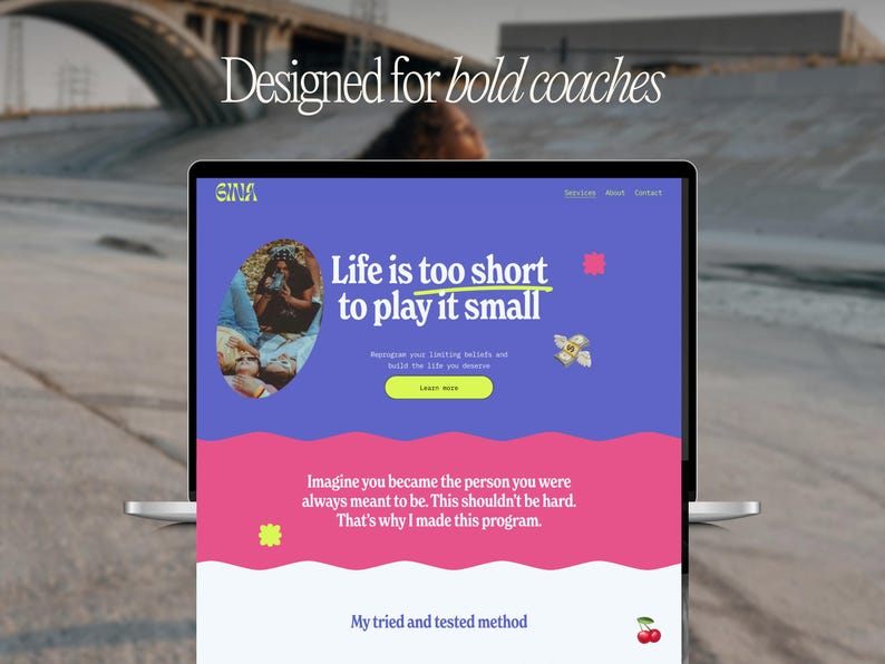 May include: A laptop screen shows a website with a purple and pink colour scheme. The text on the screen says "Life is too short to play it small." The website also features the words "Designed for bold coaches."