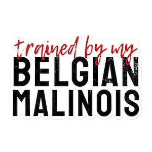 Peut inclure: Autocollant blanc avec du texte noir qui dit "trained by my BELGIAN MALINOIS" dans une police d'écriture usée. Le mot "trained" est en rouge.