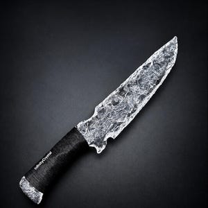 May include: A knife with a clear, textured, crystalline blade and a black wrapped handle. The handle features the white text InfinityCrystal printed on the side. The blade has an irregular, jagged edge and a translucent, ice-like appearance.