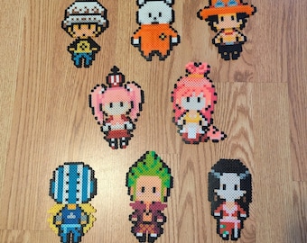 May include: A collection of eight pixel art characters from the anime One Piece. The characters are made of colorful plastic beads and are arranged in a grid pattern. The characters include Luffy, Zoro, Nami, Usopp, Sanji, Chopper, Robin, and Franky.