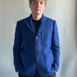 May include: A blue blazer with four buttons and two large pockets. The blazer is made of a textured fabric.