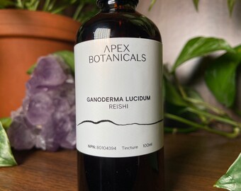 May include: A brown glass bottle with a white label that reads "APEX BOTANICALS GANODERMA LUCIDUM REISHI NPN: 80104394 Tincture 100ml".