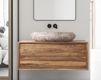 Könnte beinhalten: Ein moderner Badezimmer-Waschtisch mit einem Waschbecken aus Naturstein und zwei Schubladen. Der Waschtisch ist aus Holz und hat eine hellbraune Oberfläche. Das Waschbecken ist hellbraun und hat eine abgerundete Form. Der Waschtisch ist an der Wand montiert und hat einen Spiegel darüber.