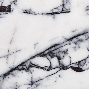 Może przedstawiać: Biały marmur z czarnymi i szarymi żyłkami. Marmur ma gładką, polerowaną powierzchnię.