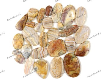 May include: A collection of 18 agate cabochons in various shades of brown, white, and red. The cabochons are smooth and polished, with intricate patterns of banding and swirling colors.