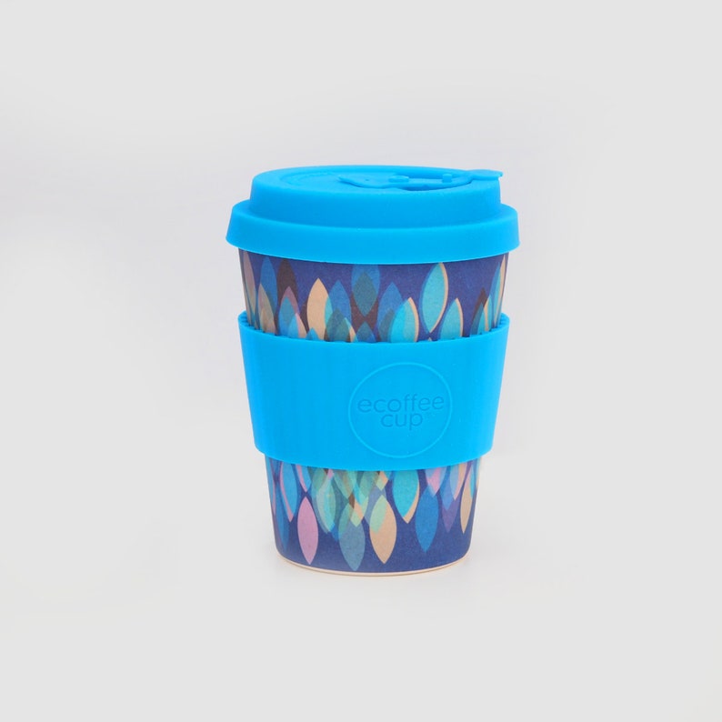 K&ouml;nnte beinhalten: Eine wiederverwendbare Kaffeetasse in Blau und Wei&szlig; mit einem blauen Silikondeckel und einem blauen Silikonband mit dem Text "ecoffee cup".