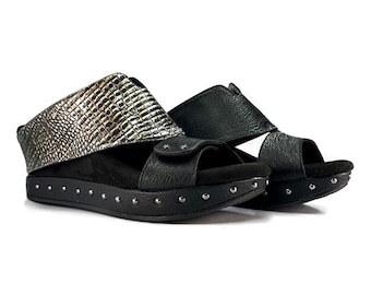 May include: Black leather sandals with a silver patterned strap and studded platform sole.