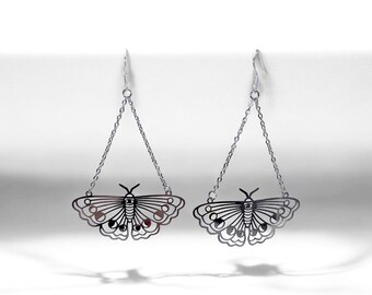 May include: Silver dangle earrings featuring a delicate butterfly design with a chain drop. The butterfly has a detailed outline and a small eye in the center.