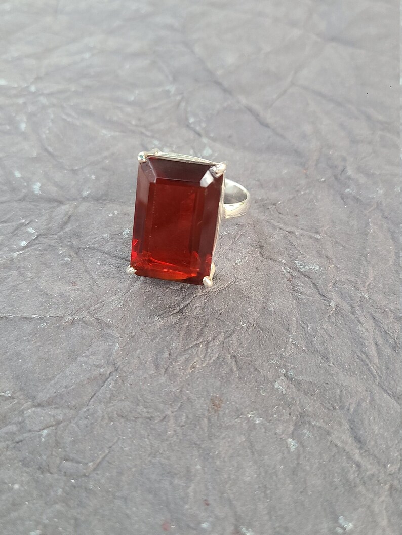 K&ouml;nnte beinhalten: Ein silberner Ring mit einem gro&szlig;en, rechteckigen, roten Edelstein.