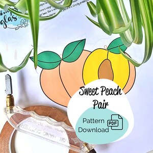 Op de afbeelding: Een digitaal downloadpatroon voor een paar perzikvormen. De perziken zijn getekend in een cartoon-stijl met een gele kern en een perzikkleurige buitenlaag. De tekst "Sweet Peach Pair" is geschreven in zwarte tekst op een turquoise achtergrond. De tekst "Pattern Download" is geschreven in zwarte tekst op een turquoise achtergrond. De tekst "PDF" is geschreven in witte tekst op een rode achtergrond.