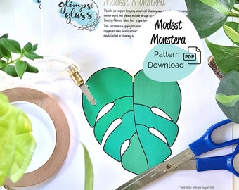 May include: A green monstera leaf pattern download, with a PDF icon, and the text "Modest Monstera Pattern Download". The image also shows a copper tape, a craft knife, and scissors.