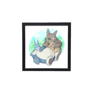 Puede incluir: Una impresi&oacute;n en acuarela enmarcada que presenta tres personajes de dibujos animados. El personaje central es una criatura grande, gris, parecida a un conejo, que sostiene una hoja. A la izquierda hay una criatura azul m&aacute;s peque&ntilde;a, y en primer plano una criatura grande, azul y redonda.