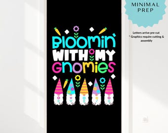 May include: A black door cover with the text "Bloomin' With My Gnomies" in bright colors. Below the text are six gnome figures with colorful hats. The door cover is designed to fit a standard door and includes pre-cut letters.