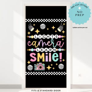 May include: Black door cover with the words "LIGHTS CAMERA LEARN SMILE!" in colorful script. The design includes stage lights, stars, disco balls, and a camera. The text "PRE-CUT LETTERS NO PREP" is also included.