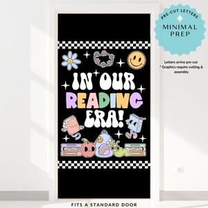 May include: Black door cover with the text "IN OUR READING ERA!" in colorful bubble letters. The design includes a smiley face, flowers, books, and a backpack. The text "PRE-CUT LETTERS MINIMAL PREP" is also included.