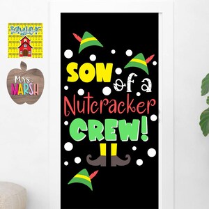 Puede incluir: Decoración de puerta negra con copos de nieve blancos y sombreros de duendes verdes. El texto dice "Son of a Nutcracker Crew!" con un par de piernas y zapatos de duendes.