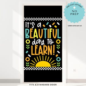 May include: A black door cover with the text "it's a BEAUTIFUL day to LEARN!" in various colors. The design includes a yellow sun, flowers, and geometric shapes. The top and bottom have a black and white checkered pattern. The text "FITS A STANDARD DOOR" is at the bottom.