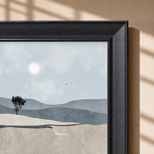May include: A framed wall art print featuring a landscape with rolling hills in shades of blue and beige. A single dark tree stands on a hill under a pale blue sky with a bright sun and small birds. The artwork is enclosed in a black textured frame.