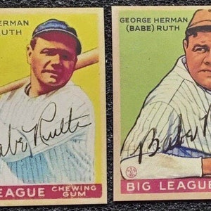 May include: Two vintage baseball cards featuring George Herman "Babe" Ruth. Both cards feature a color image of Babe Ruth in a baseball uniform with his signature in blue ink. The text on the cards reads "George Herman (Babe) Ruth" and "Big League Chewing Gum".