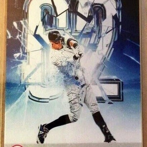 Pode incluir: Um cartão de beisebol com Aaron Judge, um jogador do New York Yankees, com um uniforme azul e branco. O cartão tem um efeito de vidro quebrado e o texto "Aaron Judge 2022 New York OF".