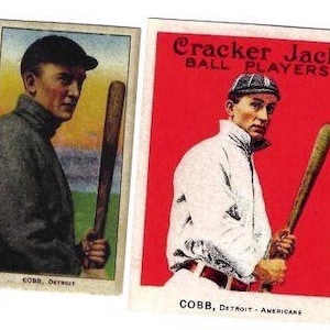 May include: Two vintage baseball cards featuring Ty Cobb, a famous baseball player. The cards are from the Cracker Jack Ball Players series. The first card shows Cobb in a dark suit holding a baseball bat. The second card shows Cobb in a white uniform holding a baseball bat. Both cards have the text "COBB, DETROIT" and the text "CRACKER JACK BALL PLAYERS" on the second card.