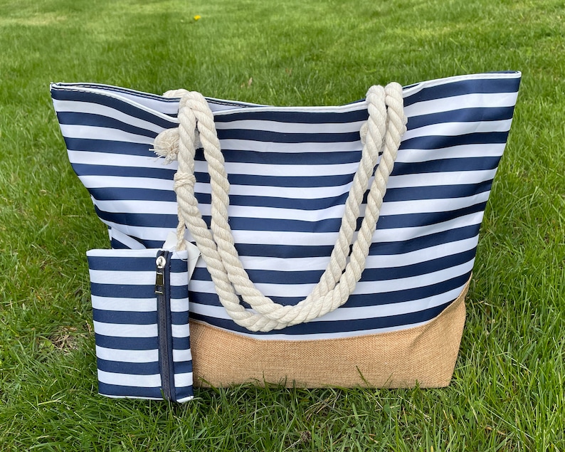 May include: A large striped tote bag with a natural jute bottom and rope handles. A smaller matching zippered pouch is included.