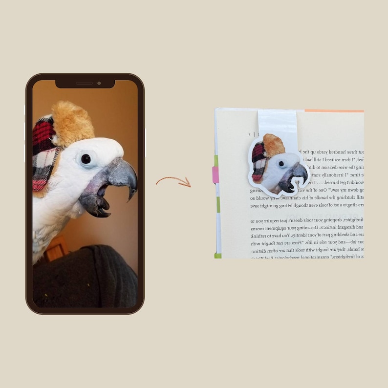 May include: A white parrot with a black beak and a plaid hat is displayed on a phone screen, with a matching bookmark on a book. The bookmark features the parrot's head and hat.