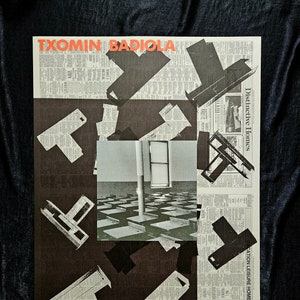 Può includere: Un poster in bianco e nero con il testo "TXOMIN BADIOLAT" in lettere rosse. Il poster presenta un collage di ritagli di giornale e una fotografia di una stanza con scrivanie e una finestra. Il testo "GALERIA JOAN PRATS" è nella parte inferiore del poster.