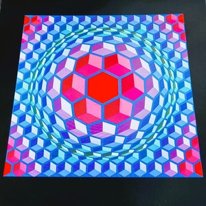 May include: A colorful optical illusion print featuring a sphere made of blue, pink, and red cubes. The sphere is surrounded by a pattern of smaller cubes.