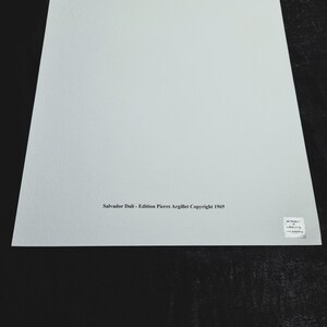 May include: A white sheet of paper with the text "Salvador Dali - Edition Pierre Argillet Copyright 1969" printed in black ink at the bottom.