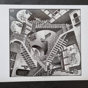 May include: Black and white print of a complex architectural design featuring staircases, arches, and figures. The artwork, signed by M.C. Escher, depicts an impossible structure with people walking on stairs in various directions.