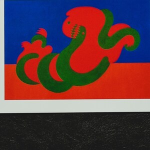 May include: Abstract art print featuring a red and green stylized creature on a blue and red background.