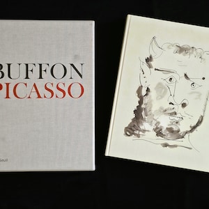 May include: Two hardcover books side by side. The left book has a light gray cover with the black text BUFFON and red text PICASSO, plus small text at the bottom. The right book has a white cover featuring a black ink sketch of a horned creature.