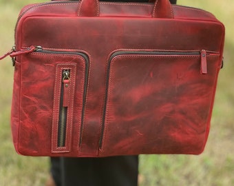 May include: A red leather laptop bag with a zippered pocket and a top handle.