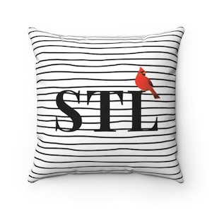 May include: White and black striped pillow with the text "STL" in black and a red cardinal bird on the right side.
