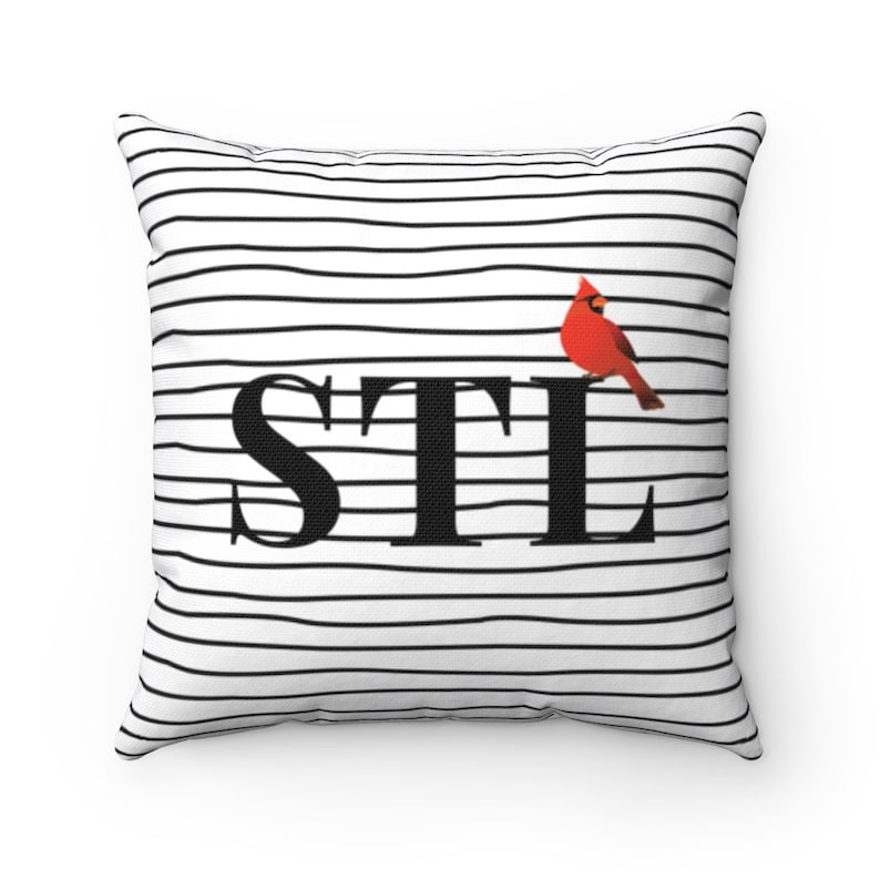 May include: White and black striped pillow with the text "STL" in black and a red cardinal bird on the right side.