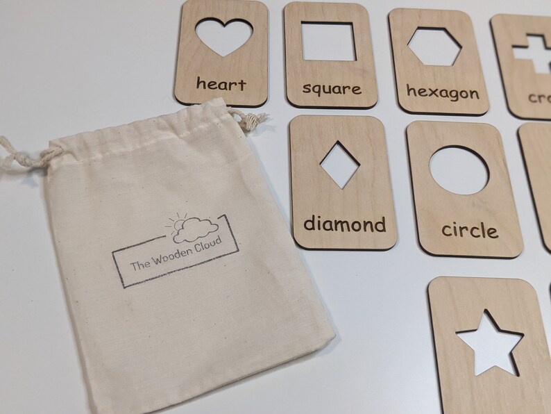 Peut inclure: Cartes de formes en bois avec des d&eacute;coupes en forme de c&oelig;ur, carr&eacute;, hexagone, croix, losange, cercle et &eacute;toile. Les cartes sont en bois clair et comprennent les noms des formes. Un sac en toile avec le logo "The Wooden Cloud" est inclus.
