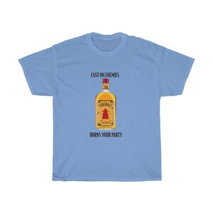 May include: Light blue t-shirt with a black graphic of a bottle of Fireball whiskey. The text "Cast on enemies" and "Burns your party" is printed on the shirt.