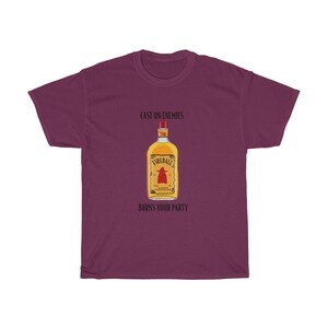 May include: A maroon t-shirt with the text "Cast on enemies" and "Burns your party" printed on it. A bottle of Fireball whiskey is pictured in the centre of the shirt.