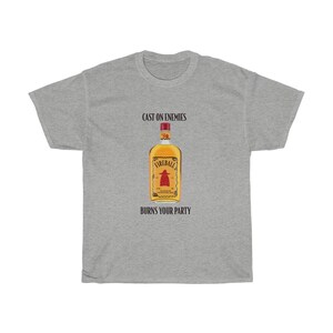 May include: A grey t-shirt with the text "Cast on enemies" and "Burns your party" printed on it. A bottle of Fireball whiskey is pictured in the centre of the shirt.